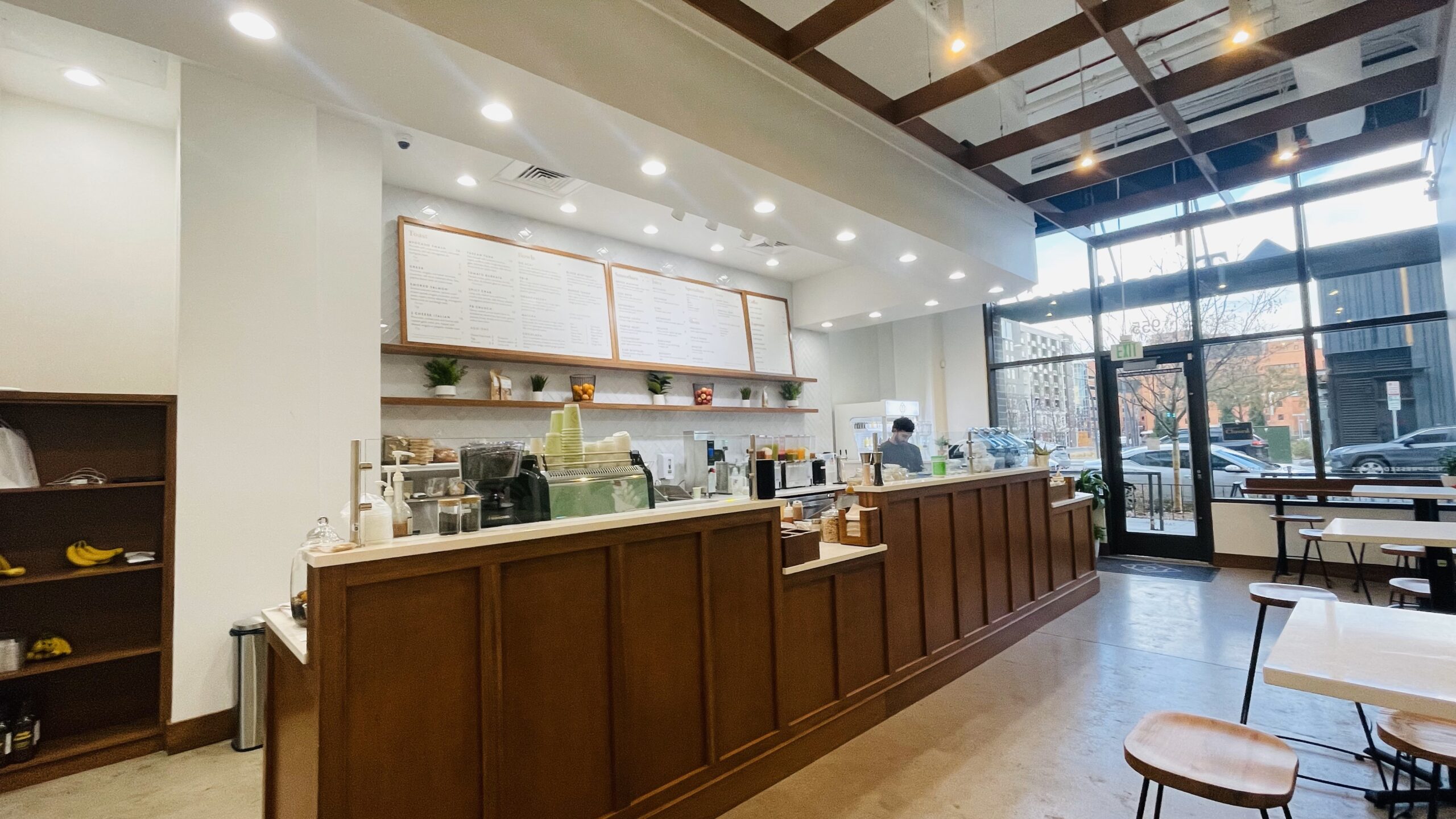 Toastique interior with a wood service counter, seating, and daylight from street-facing windows.