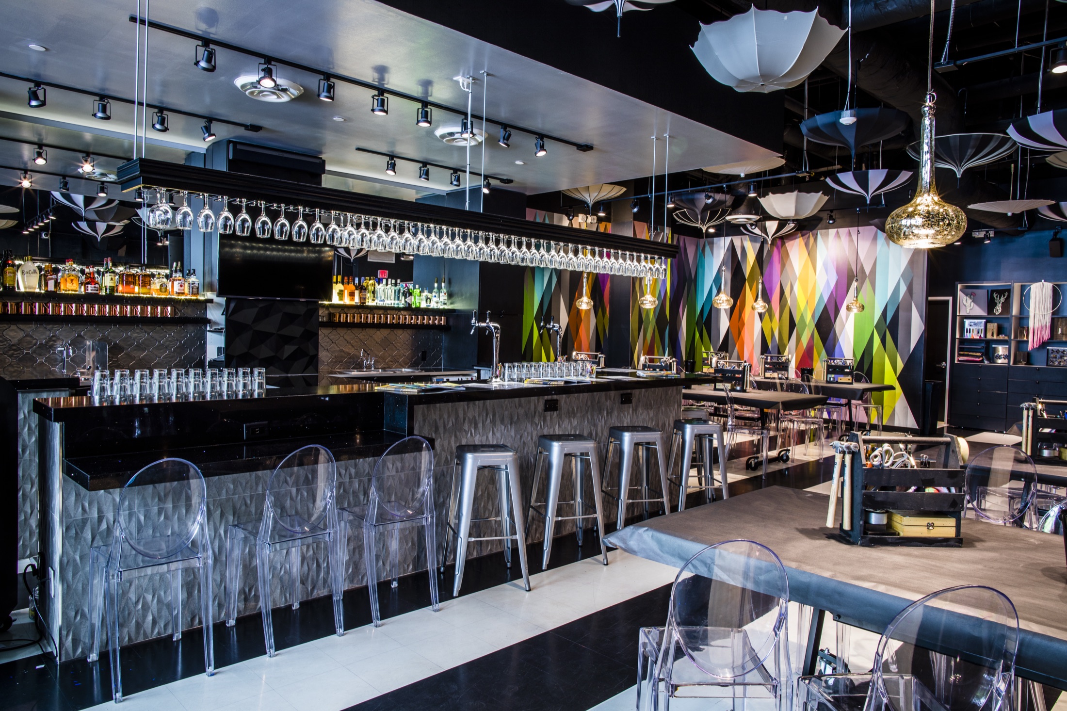 Bar and seating at Upstairs Circus in Austin, with patterned walls and hanging parasols.